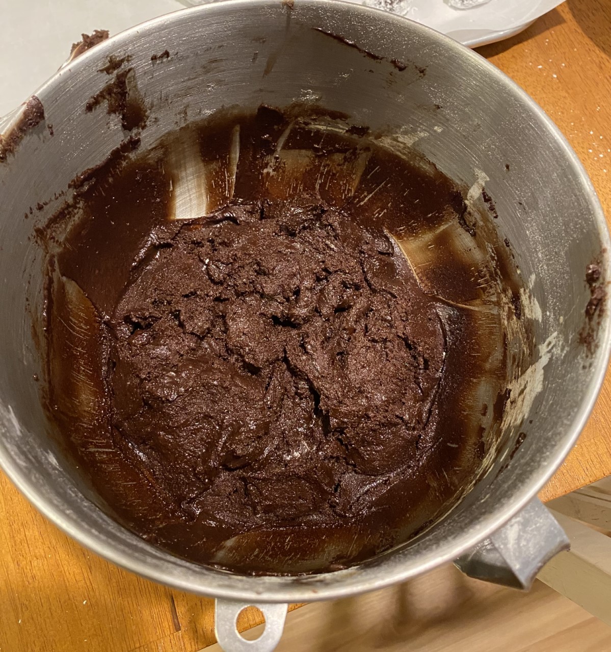 Inside a large, stainless steel mixing bowl is a fudgey cookie dough