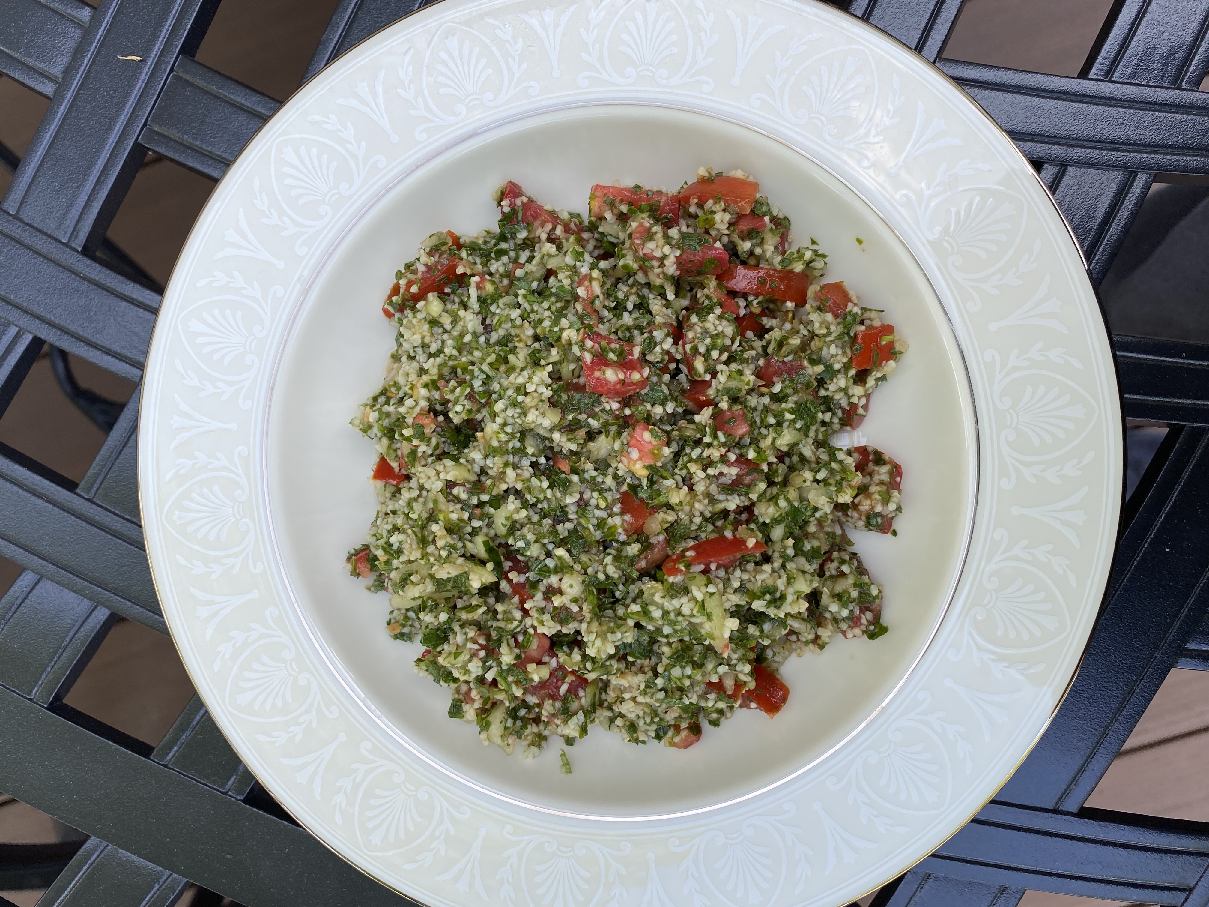 A white bowl of fresh Tabbouleh salad on a table